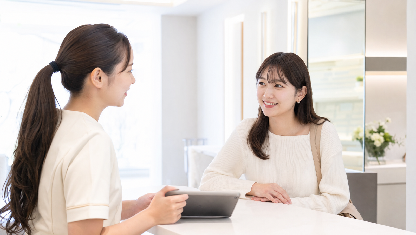 クリニックのカウンターでカウンセラーに相談する女性