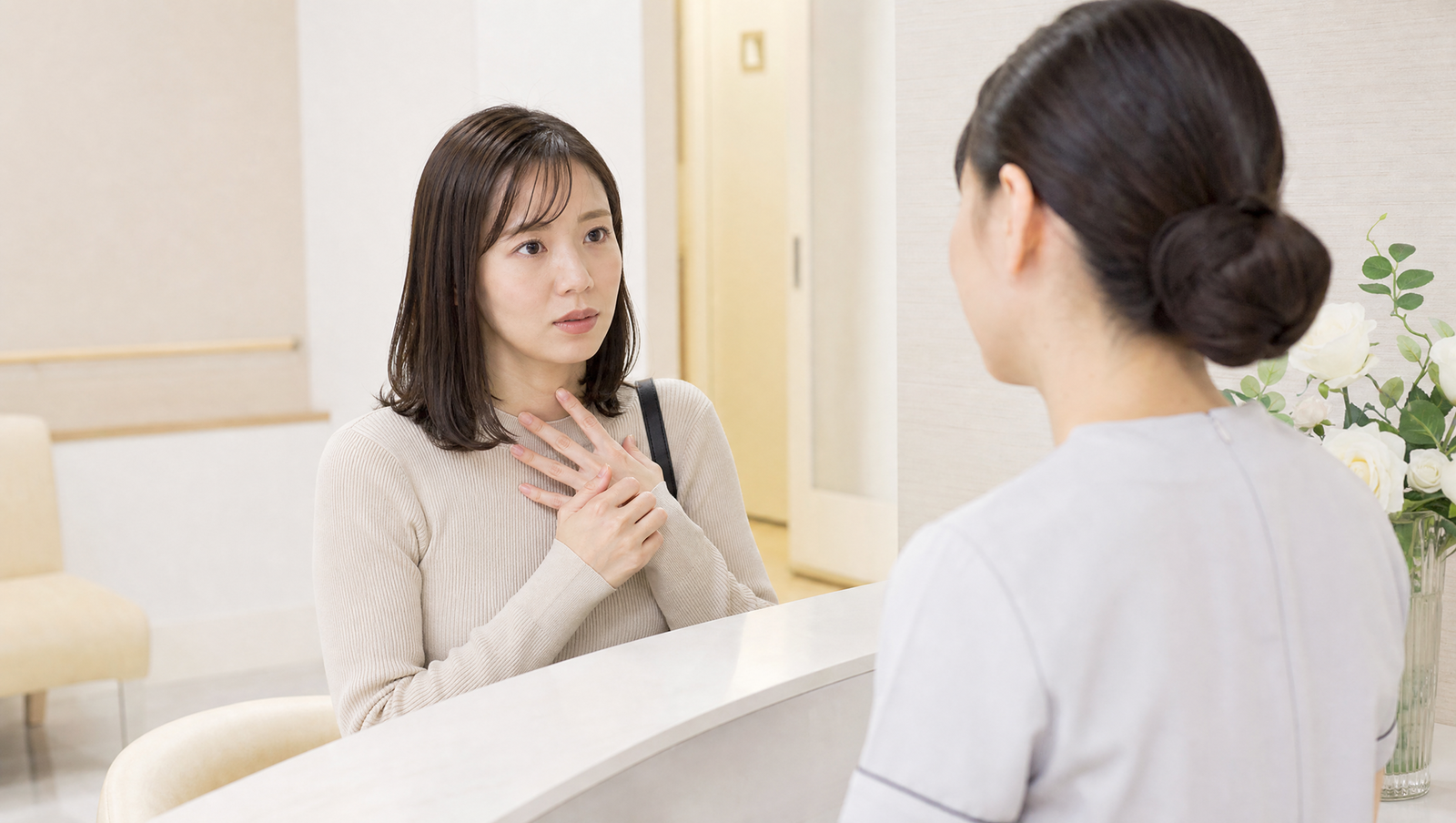 クリニックでスタッフに相談する女性